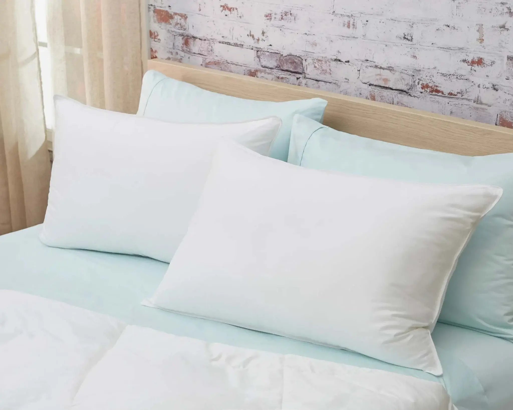 Premium down alternative pillow on bed with white cotton sateen cover and medium fill.