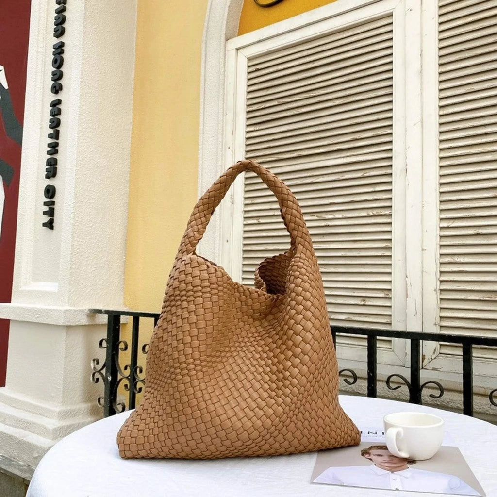 Woven neoprene tote with removable zipper pouch on outdoor table.