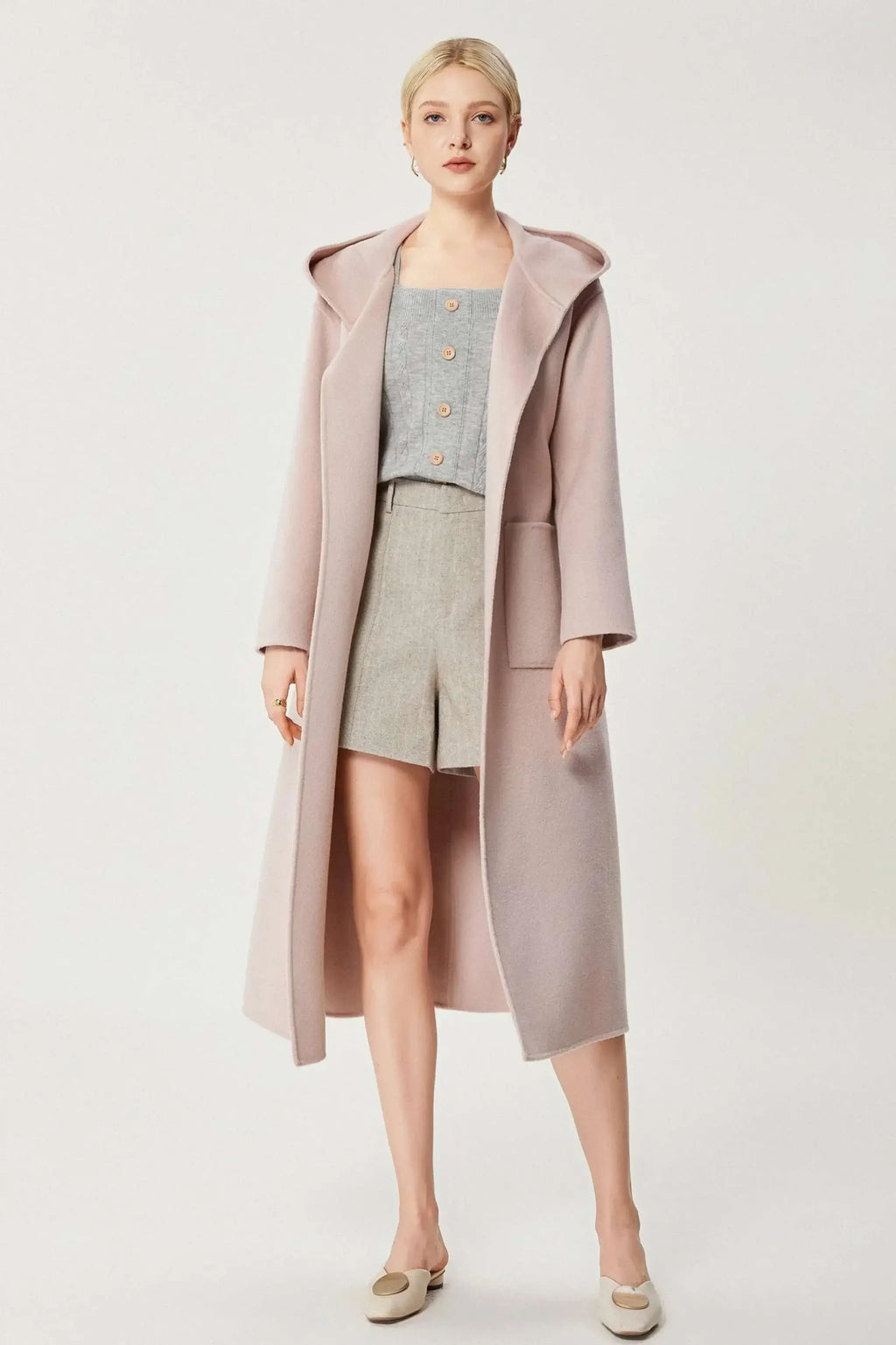 Luxurious baby pink cashmere coat with A-line design and matching belt.