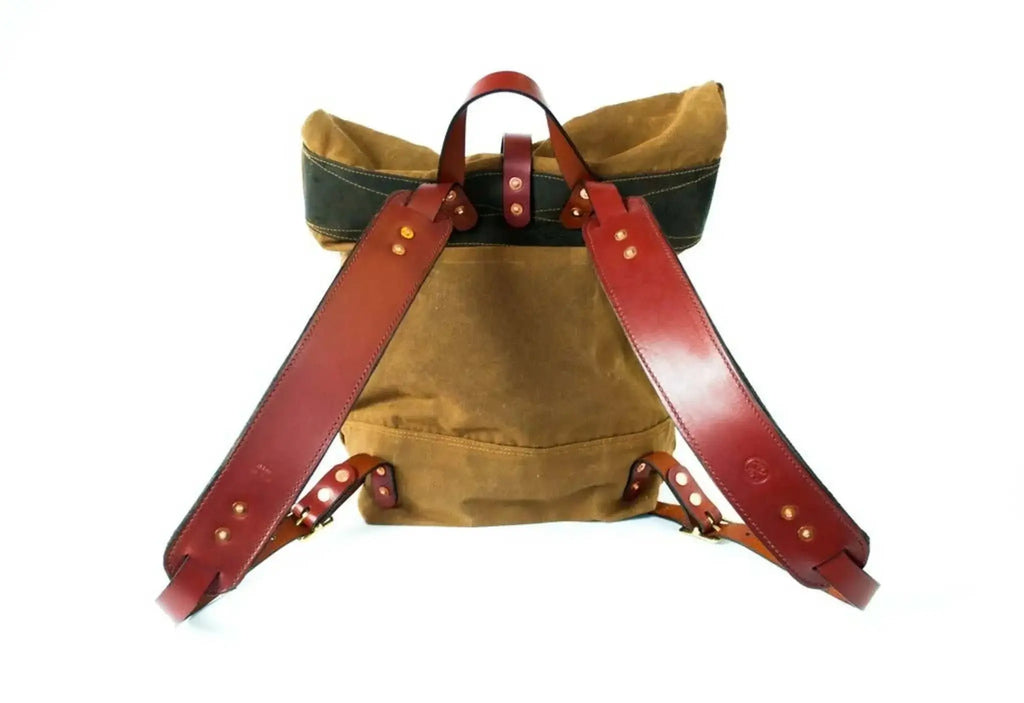 Durable waxed canvas backpack with chestnut leather straps and rolltop closure.