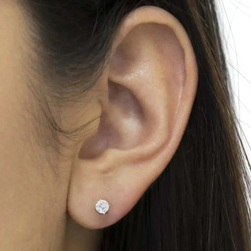 10K yellow gold round brilliant-cut diamond stud earring on ear showing sparkle and elegance.