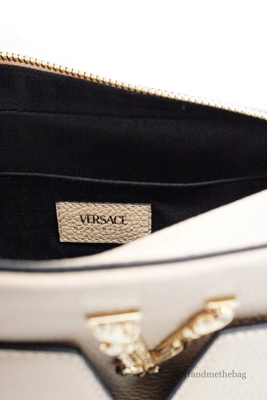 Versace Virtus small beige leather camera crossbody bag with V logo and adjustable strap.