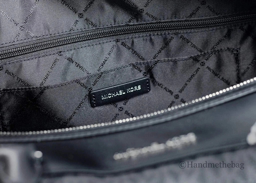 Interior view of Michael Kors Travel Extra Large Black Duffel Bag showing jacquard lining and Michael Kors logo.