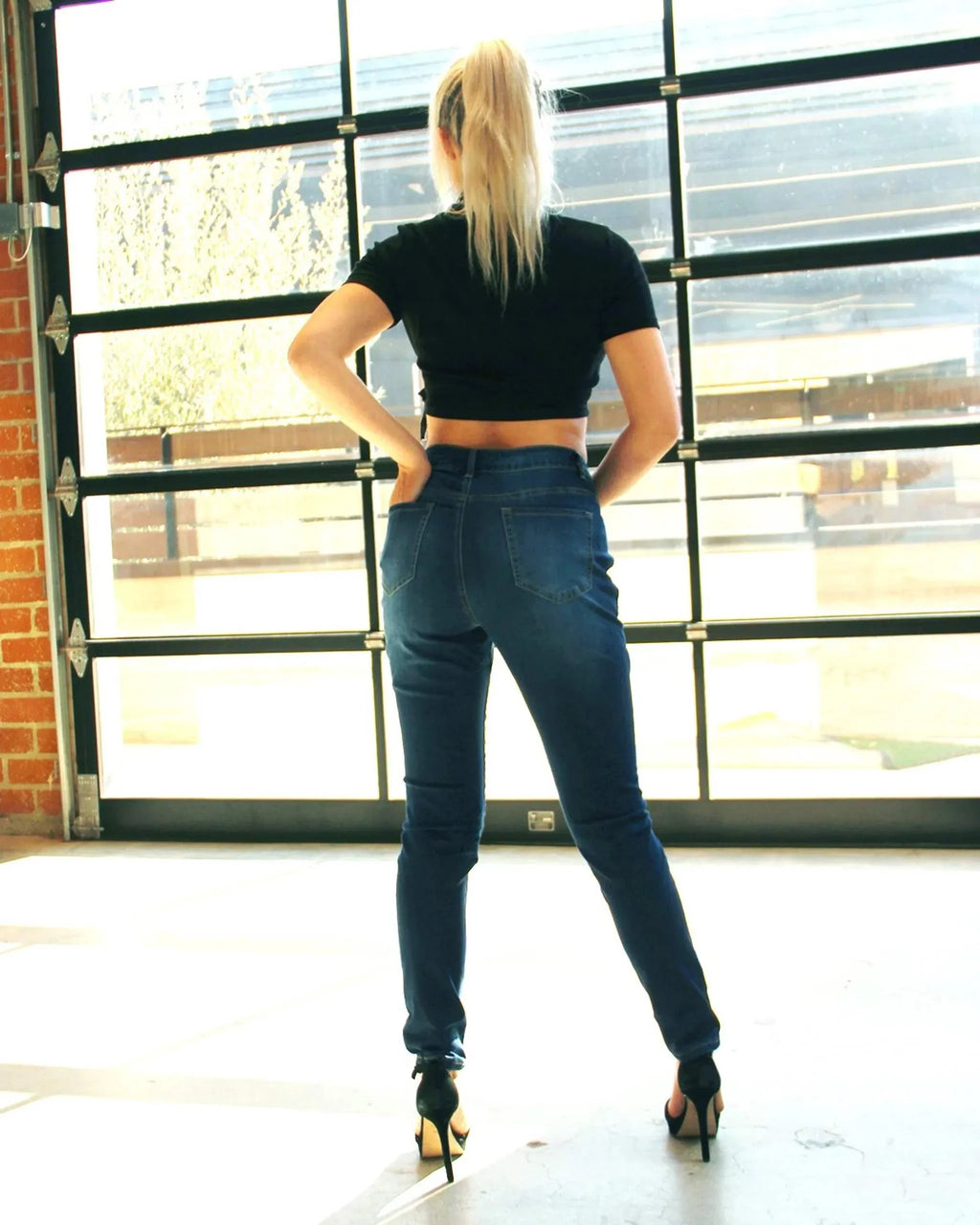 Woman wearing Cabrillo Faded Jeans with mid-rise waist and five-pocket design.
